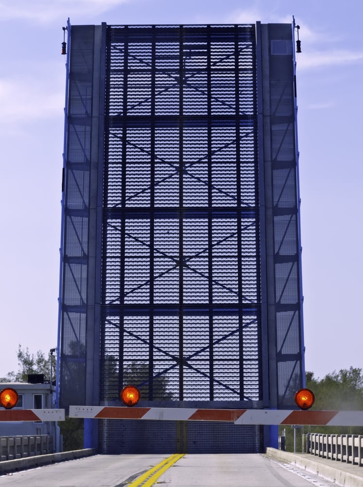 Bascule bridge in raised position on two-lane road across waterway on Gulf coast of Florida