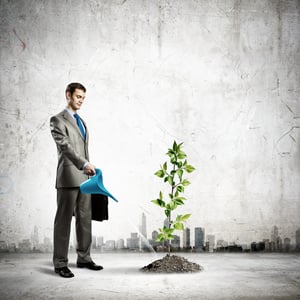 Image of businessman watering sprout with can.jpeg