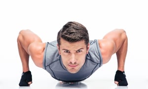 Sports young man doing push ups isolated on a white background.jpeg