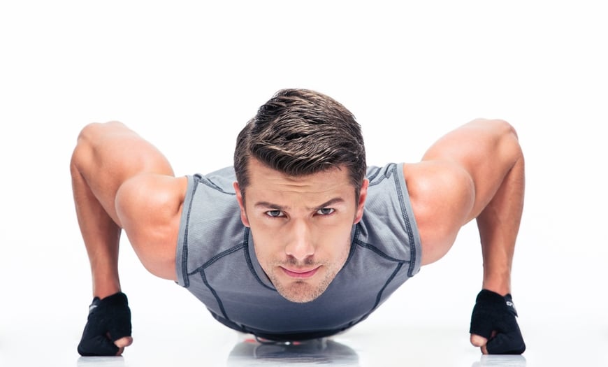 Sports young man doing push ups isolated on a white background.jpeg